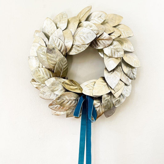 Gold and silver magnolia leaves wreath with French blue velvet bow at the bottom of wreath and long tails